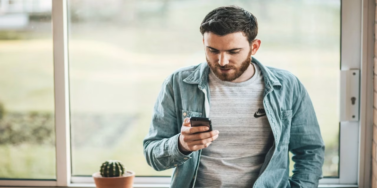 cancelar seguro homem segurando celular para cancelar seguro residencial