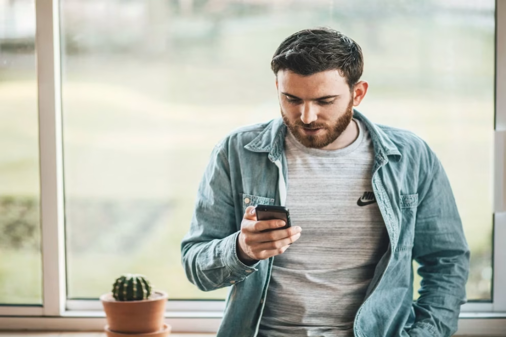 cancelar seguro homem segurando celular para cancelar seguro residencial