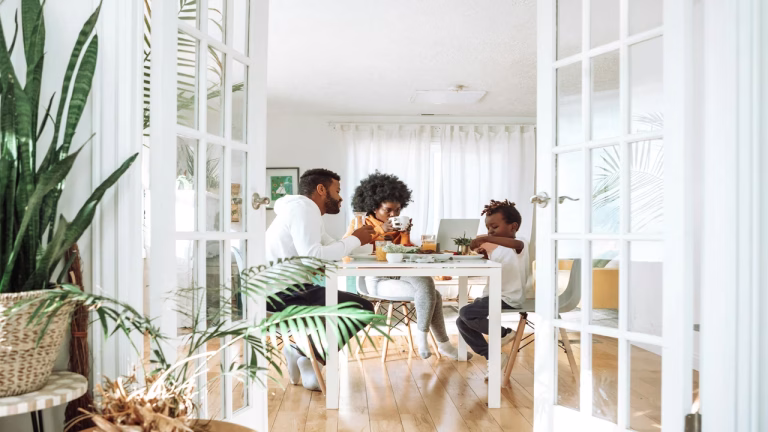 familia sentada na mesa analisando se o seguro da caixa é a melhor opção